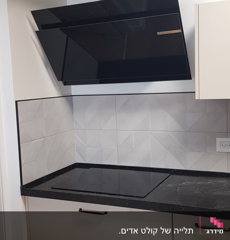 כיריים שחורות ומכסה קולט אדים במטבח מודרני